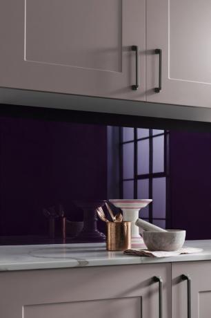 紫色のスプラッシュバックとピンクのキッチンキャビネット