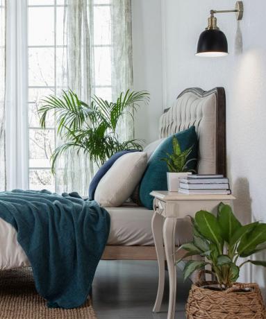 Iconic Lightsin vintage messinkivärinen makuuhuoneen seinävalaistusidea kermanvärisellä sängyllä, sinivihreillä ja tyynyillä
