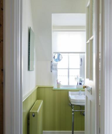 ნაცრისფერი სამზარეულო სკამის სარკინიგზო სიმაღლეზე თეთრი კედლებით და ვერცხლისფერი აქცენტებით ონკანების ჩათვლით