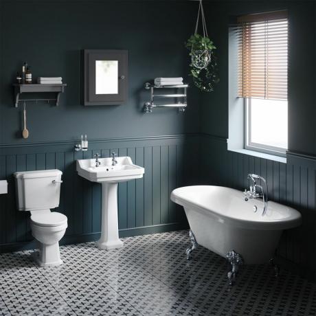 traditionel badeværelsessuite med badekar med rulletop, dybblå panelvægge og mønstret gulv