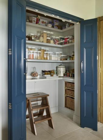 Sisäänrakennettu ruokakomero, jossa on hyllyt ja siniset taitto -ovet