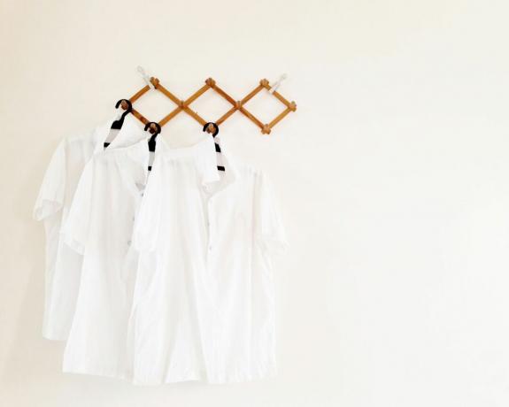 자외선 차단제 얼룩을 제거하는 방법 - 옷걸이에 붙은 흰색 셔츠 - GettyImages-1140091714