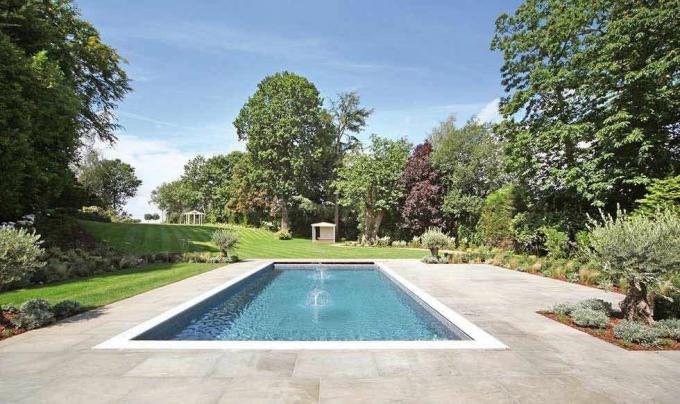 piscina su un grande patio in un giardino