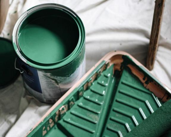Una lata de pintura verde y bandeja de pintura.