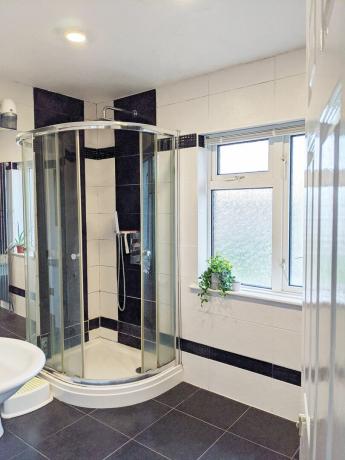 Foto antes do banheiro com chuveiro de canto e azulejos preto e branco