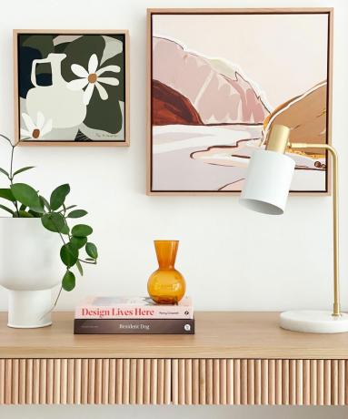 moderne og lys stue med riflet sidebord i tre med kunstverk i jordfarge