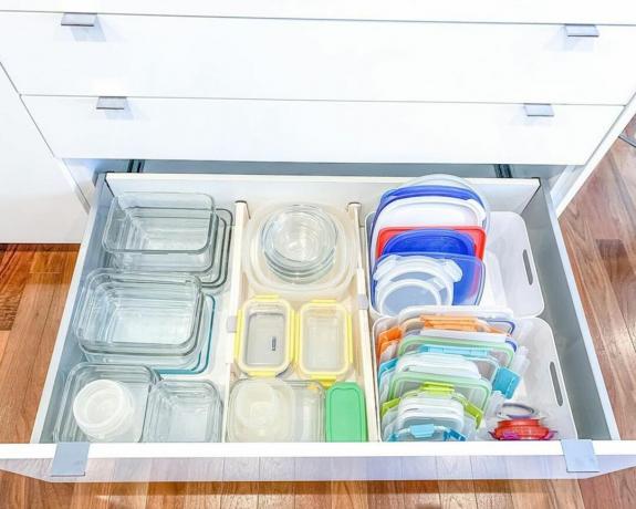 Eine weiße Küchenschublade mit einer Reihe bunt organisierter Lebensmittelbehälter