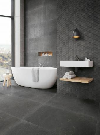kupaonica u sivim tonovima u prostoru s otvorenim prozorima, samostojećom kadom i zidnom umivaonikom i spremištem