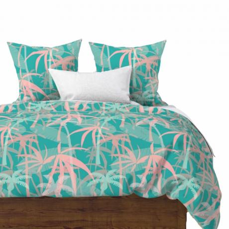 Un set de lenjerie de pat cu imprimeu cu palmieri turcoaz și roz pastel