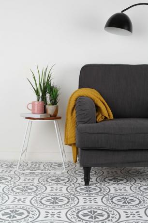 Suelo de plantilla pintado con sofá y mesa auxiliar.