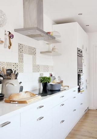weiße Einheiten mit teuren Armaturen in einer Wohnküche im skandinavischen Stil