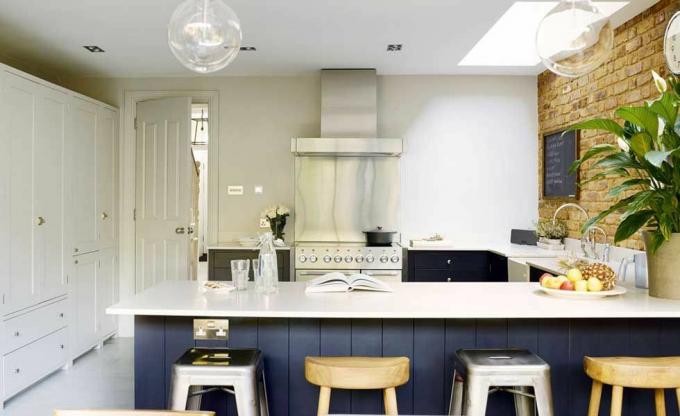 keuken in industriële stijl met niet-passende barkrukken en heldere gloeilampen
