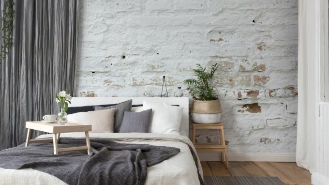 Белоснежные кирпичные обои от Wallsauce в нейтрально-серой спальне с деревянным полом и комнатными растениями