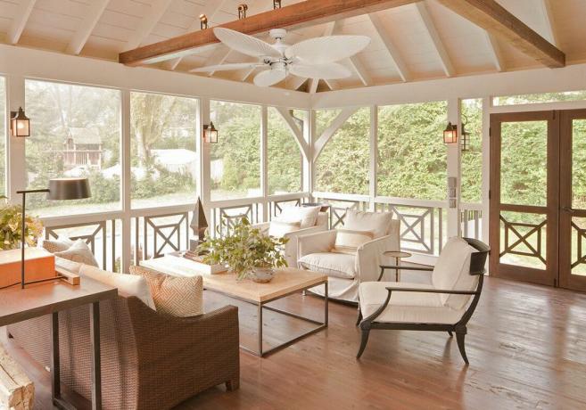 terraza acristalada / porche con suelo de madera, sofás y sillas neutrales