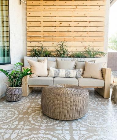 Ein DIY-Sofa für den Außenbereich mit einer Auswahl an neutralem Kissendekor für den Außenbereich auf einem dekorativen Terrassenboden