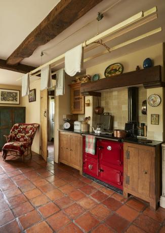 lite kjøkken i landlig stil med rød aga i hyttehuset