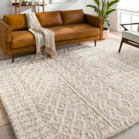 Krémszínű geometrikus szőnyeg bőr kanapéval 