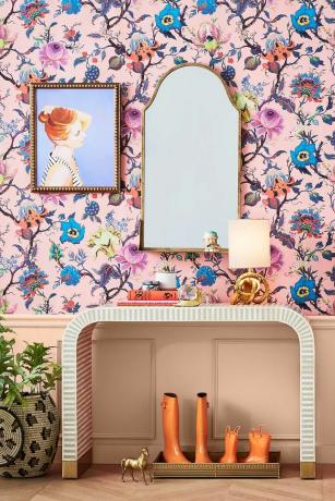 Roze en blauw behang in de hal met witte console en spiegel