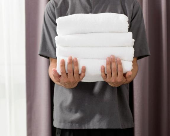 Uomo con una pila di asciugamani piegati
