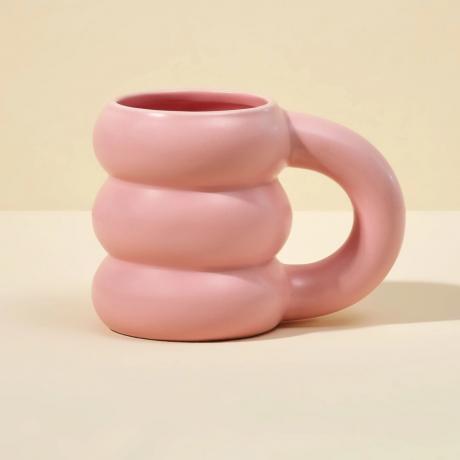 Una taza de burbujas de color rosa pastel con crestas