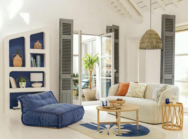 salon blanc aux accents bleus, sol blanc, mobilier moderne, plafond voûté, volets gris