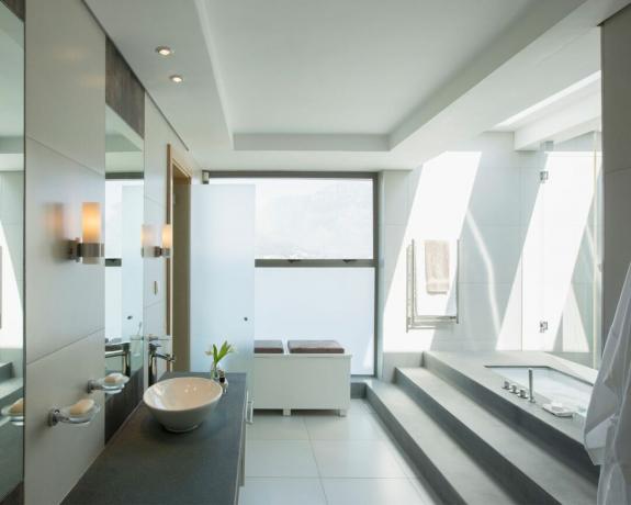 Tepsi tavanlı ve büyük pencereli modern bir banyo