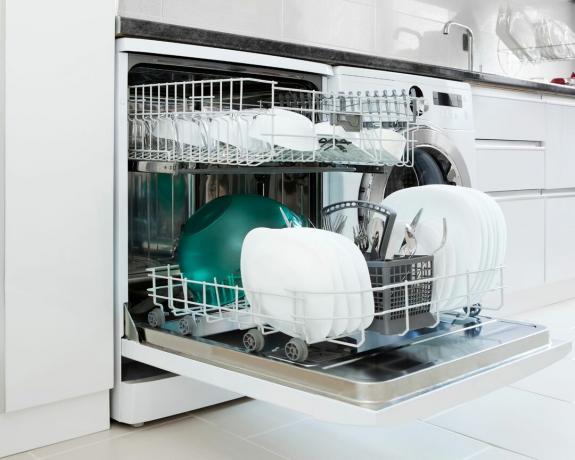 Máquina de lavar louça aberta com pratos