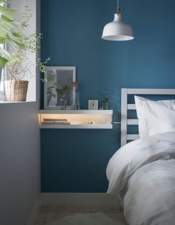 nattbord laget av to bildehyller med blå vegger og hvitt sengetøy