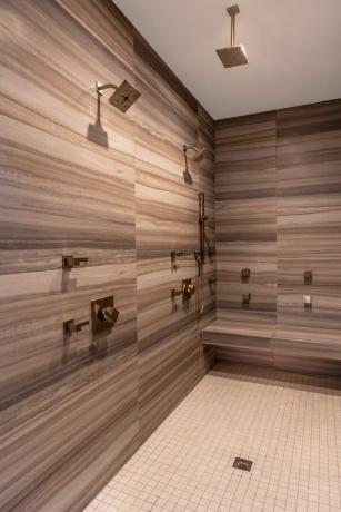 piastrelle doccia neutre a strisce, doppia doccia in ottone, panca doccia, piccole piastrelle quadrate sul pavimento