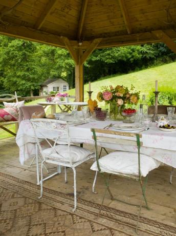 sala de jantar ao ar livre com flores e lençóis
