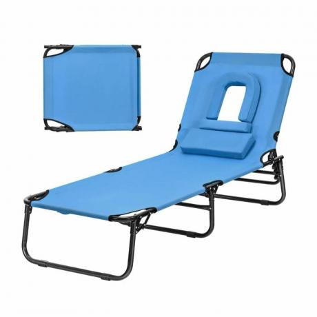 En lænestol i blåt stof med hovedhul og pude