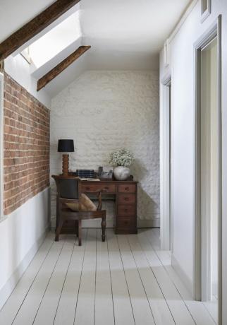 corredor de tijolos com mesa e cadeira de madeira