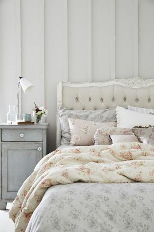 Jednoduchý pokoj ve francouzském stylu s květinovým povlečením a francouzskou postelí