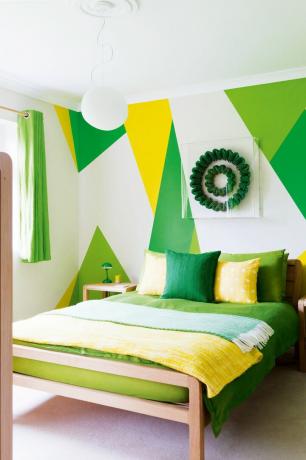 Rohelise ja kollase geomeetrilise mustriga kaunistatud magamistuba