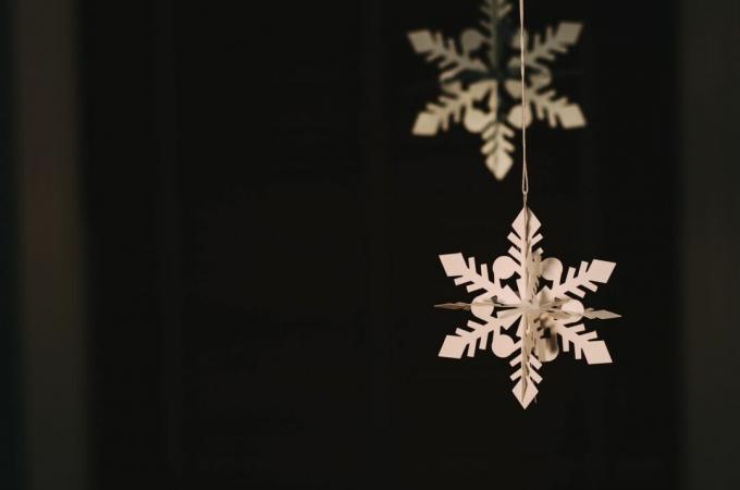 mirdzošas papīra sniegpārslas karājas pie Ziemassvētku eglītes