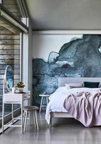 جدار رمادي درامي مميز في غرفة أرضية خشبية مع خزانة ملابس وأغطية سرير باللون الوردي