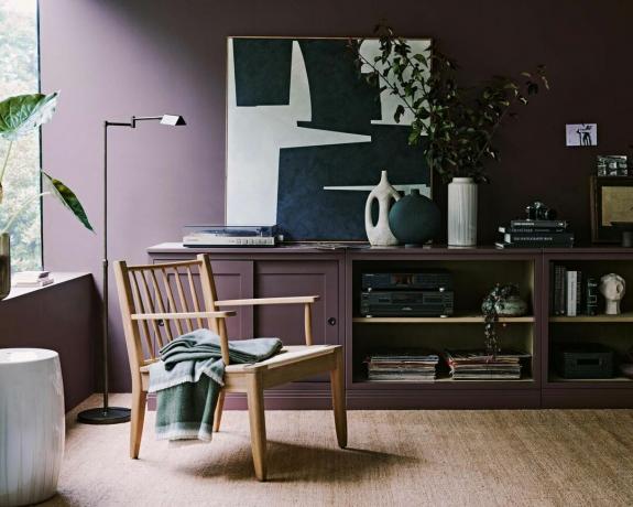 moderná obývacia izba so vstavanou skriňou, dreveným kreslom a prirodzeným svetlom