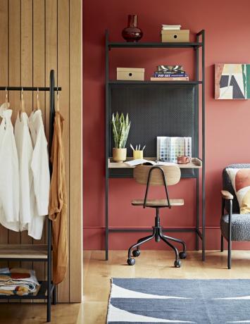 orange hjemmekontor i stue åbent skrivebord med hylder og skammel