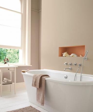 Beige kylpyhuone, jossa on kontrastivärinen syvennys ja koristeltu simpukoilla