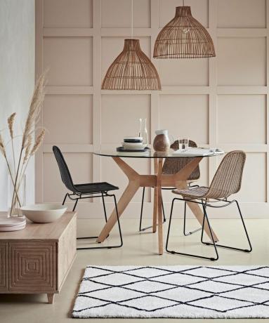 Configuración de comedor artesanal con luz de ratán, alfombra bereber y mesas y sillas de madera de Habitat