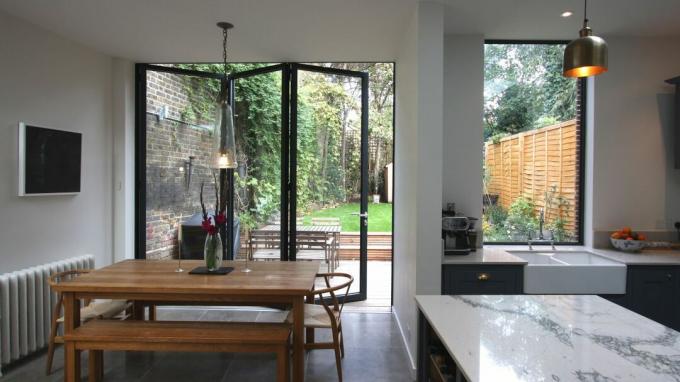 Kaip apsaugoti savo namus: atviro plano virtuvės priestatas su stilingomis dvigubomis durimis