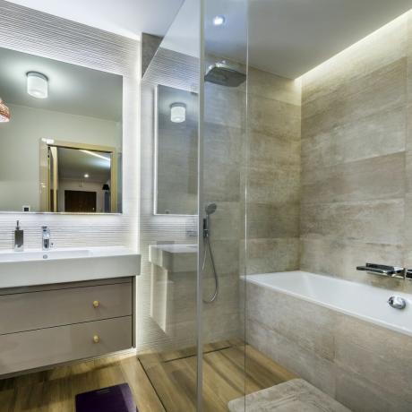 Modernus vonios kambarys su medinėmis grindimis stilingame bute