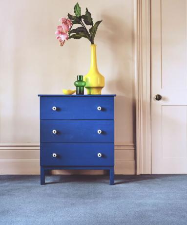 Niebieski zestaw szuflad w różowym pokoju z niebieskim dywanem