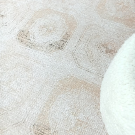 Un tappeto beige sul pavimento con un cuscino bianco