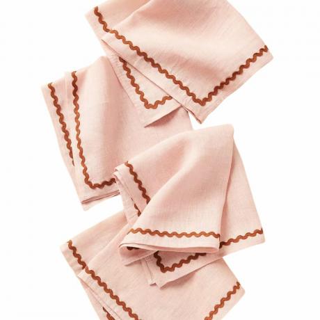 Um conjunto de guardanapos de linho com bordas onduladas rosa pastel
