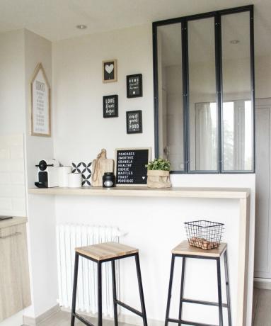 Idee de colț de cafea cu tejghea în stil bar pentru mic dejun, scaune de bar și imprimeuri tipografice înrămate în paletă mono și lemn.