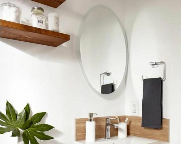 Šviesus vonios kambarys su veidrodžiu ir lentynomis