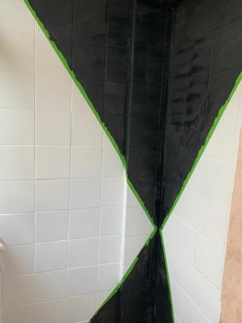 검은색 페인팅이 있는 개구리 테이프로 표시된 타일 벽