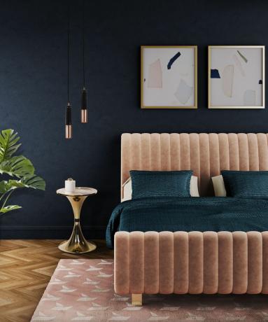 letto rosa in una camera da letto blu scuro con opere d'arte incorniciate
