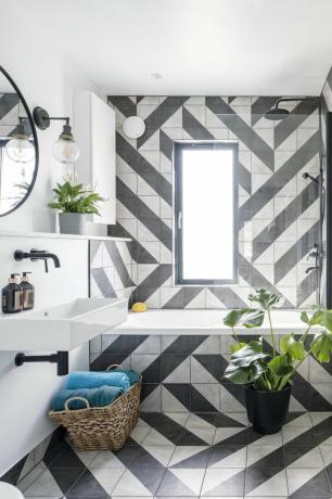 Ванная комната с зигзагообразной черно-белой плиткой от пола до панели ванны на стене